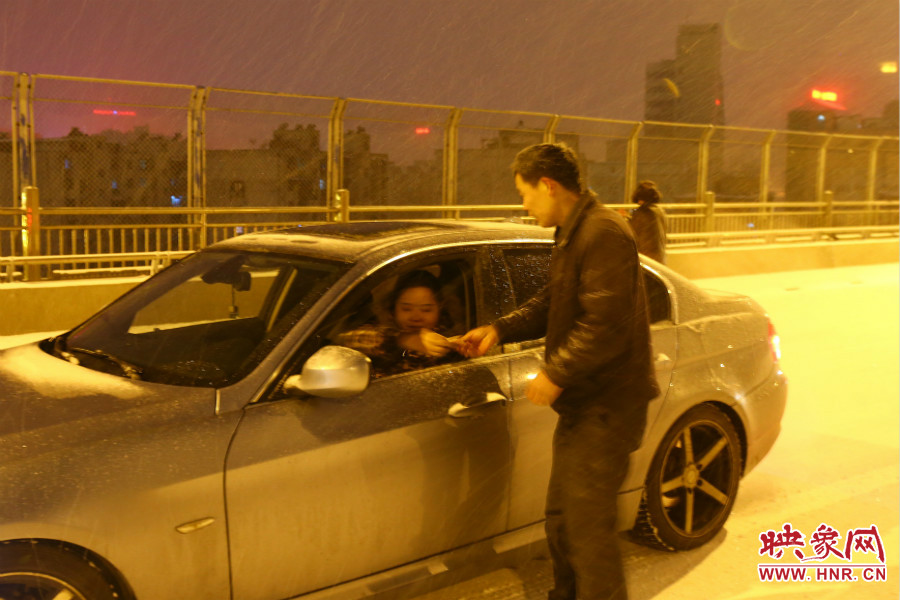 “推車人”幫助一輛車上坡后，收取“勞務(wù)費(fèi)”。