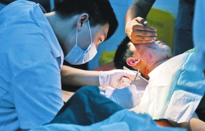 孩子身上有7道傷痕，其中兩道需要縫合，其他的均為擦傷，醫(yī)生正對(duì)他施治。