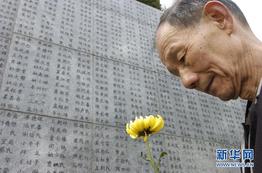 2006年4月5日，74歲的南京大屠殺幸存者佘子清手捧鮮花，祭奠被日軍殺害的母親。