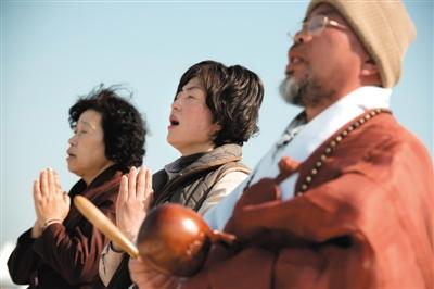 23日，一名僧侶引領(lǐng)人們?yōu)樗勒咂矶\。