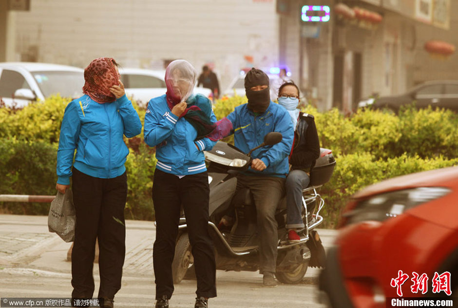 2014年04月23日，新疆維吾爾自治區(qū)吐魯番地區(qū)，市民戴著口罩行走在大風(fēng)沙塵中的吐魯番市街頭。