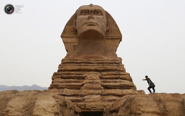 石家莊郊外，一名男子與山寨版獅身人面像合影留念。