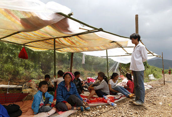 暴雨馬上來臨，村民們在簡易帳篷下躲雨。澎湃新聞 程藝輝 圖