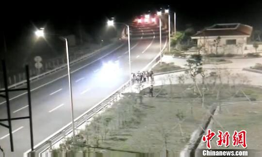 看到車輛經(jīng)過，孩子們便急忙跑到一旁的花圃上?！【焦﹫D　攝