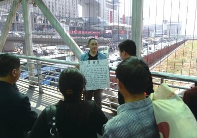 韓先生在北京西站天橋上籌錢。京華時(shí)報(bào)記者陶冉攝