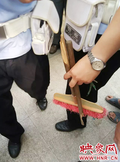 老太從環(huán)衛(wèi)工手中奪過掃帚，用腳踩斷，用力向環(huán)衛(wèi)工人的手上和腿上敲去。