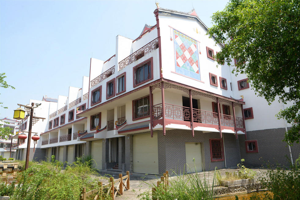 2016年7月26日，村民在廣西來賓市忻城縣隆達(dá)山水福城荒廢別墅間放牛。