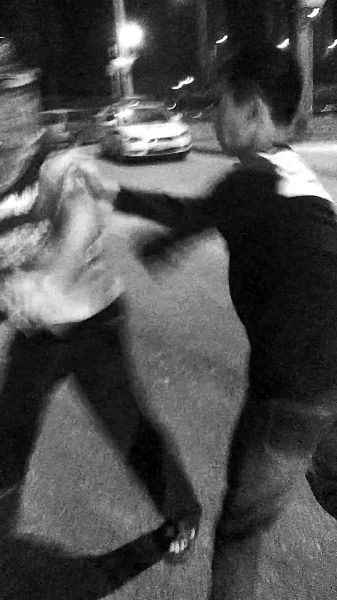 一名男子扯著民警的反光背心一路追打。