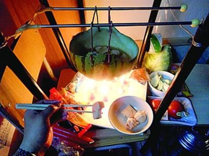 兩張椅子被面對面疊在一起，穿了兩根線的西瓜皮就懸空在椅腳中間，下面有蠟燭加熱，這就是西瓜火鍋。