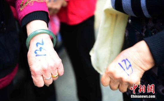 圖為10月28日，在江西九江市一家羊絨皮草服裝服飾博覽會(huì)現(xiàn)場(chǎng)，老人們正在頂著寒風(fēng)排隊(duì)等待領(lǐng)取10元代金劵。