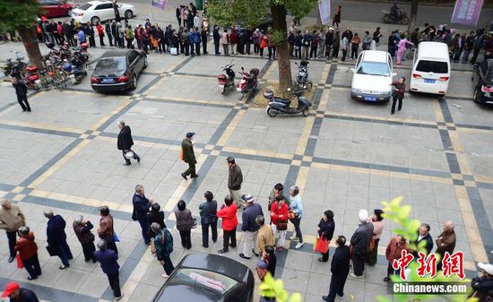 圖為10月28日，在江西九江市一家羊絨皮草服裝服飾博覽會(huì)現(xiàn)場(chǎng)，老人們正在頂著寒風(fēng)排隊(duì)等待領(lǐng)取10元代金劵。