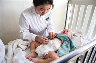 昨日，北京兒童醫(yī)院，護(hù)士為即將出院的被扎鋼針女嬰檢查傷口恢復(fù)情況。記者 高瑋 攝