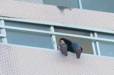 28樓的窗臺(tái)上坐著一名女子，其兩條腿耷拉在室外，不停地?cái)[動(dòng)。